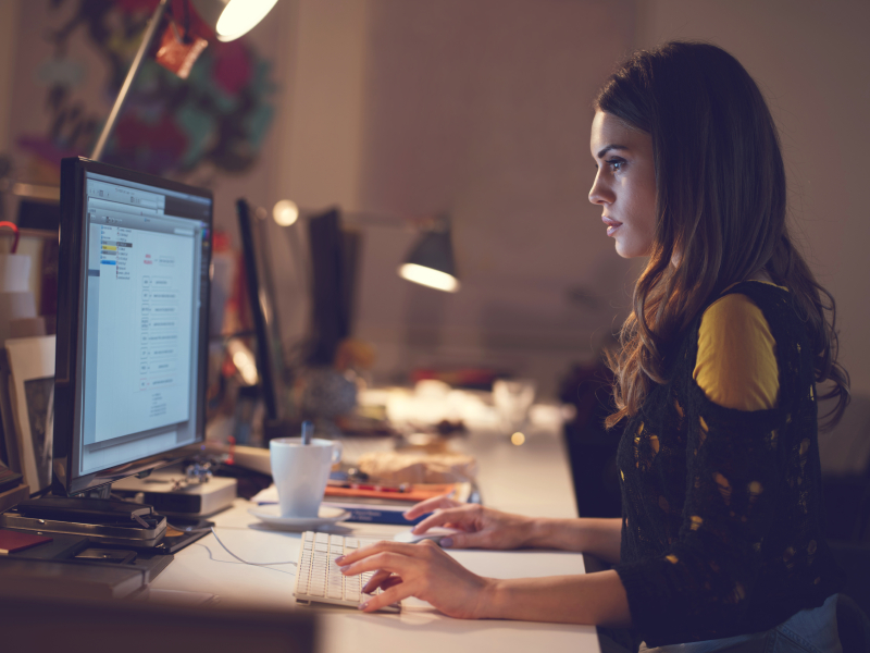 Side view of a woman working on a computer.